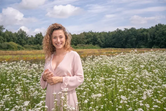 A woman standing in a daisy meadow.