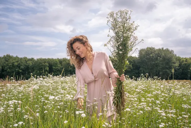 A woman in a meadow full of daisies.